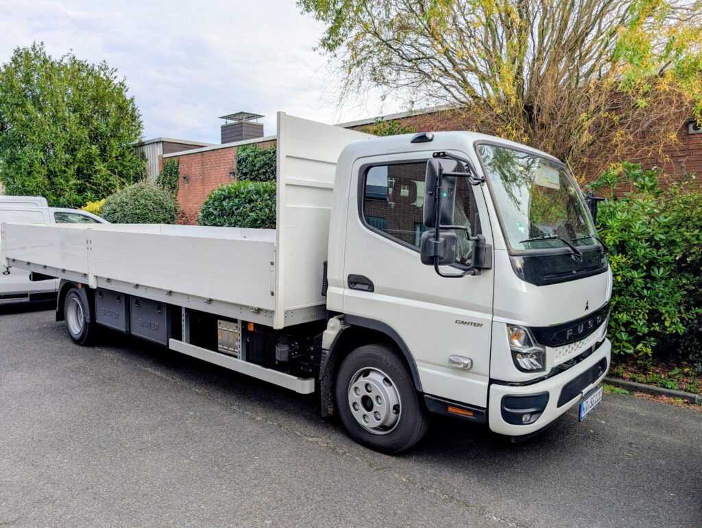 Ein weißer LKW steht vor einem Gebäude
